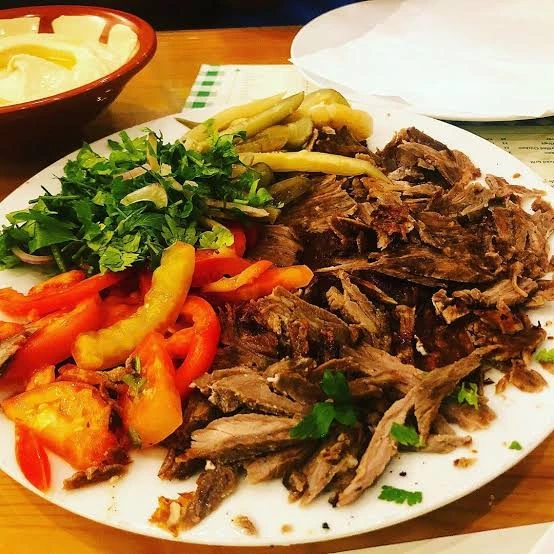 وجبة عائلية من مطعم مشوي وصاج تضم مشاوي وصاج ومقبلات مثل الحمص والتبولة